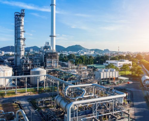 Aerial view of chemical oil refinery plant, power plant on blue sky background.